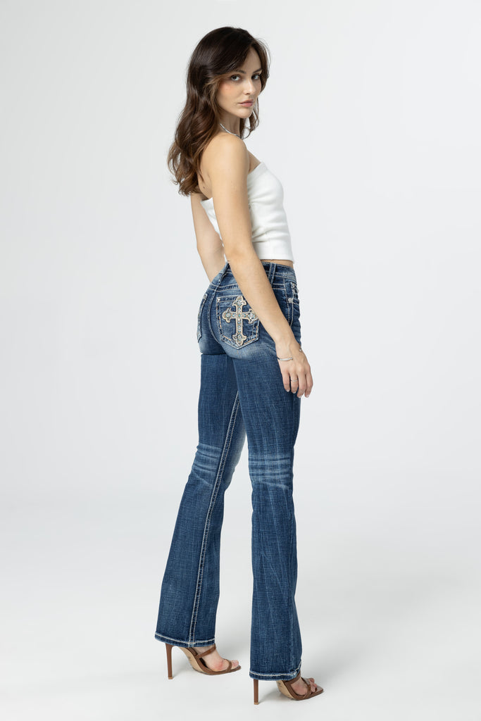 side profile of model wearing aztec embroidered cross-designed jeans